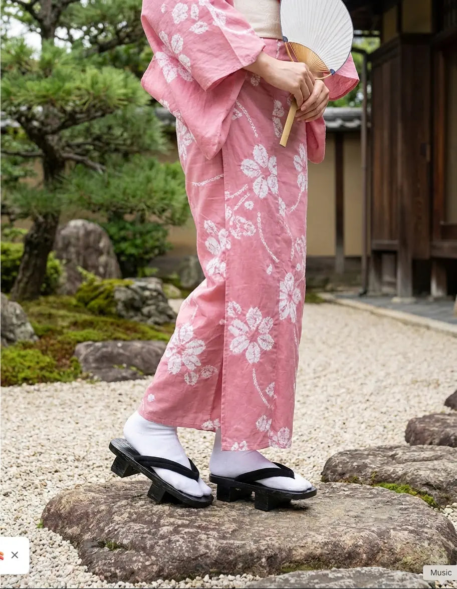 Geta Sandalen erneut getragen mit einem rosa Kimono in einem japanischen Garten