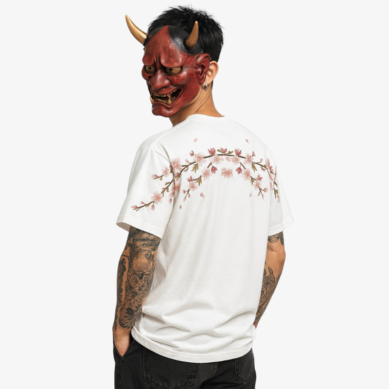 Person trägt weißes besticktes Sakura-Hemd mit roter Maske im Streetwear-Look