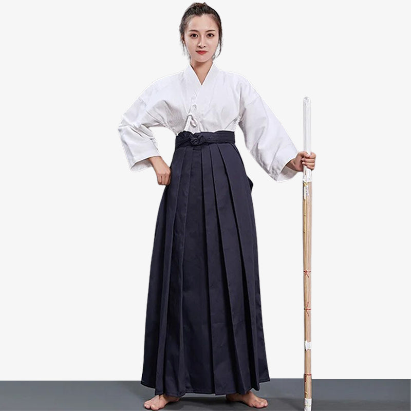 Kampfkünstlerin trägt Damen Hakama Hose mit weißem Keikogi und Holzschwert