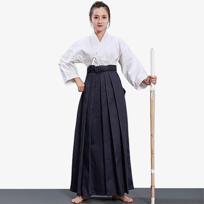 Kampfkünstlerin trägt Damen Hakama Hose mit weißem Keikogi und Holzschwert