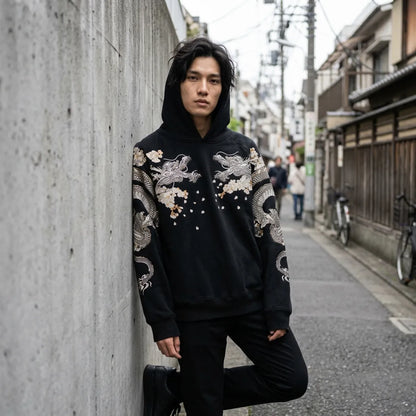 Streetwear Hoodie mit hochgezogener Kapuze vor einer Betonwand in Tokio