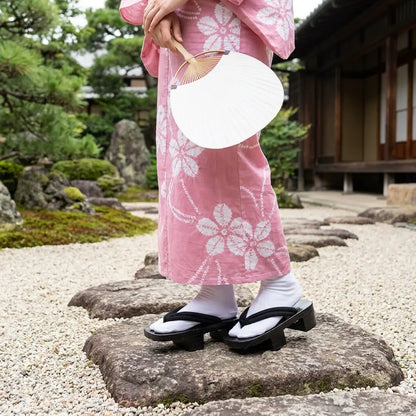 Geta Sandalen Damen getragen mit einem rosa Kimono in einem japanischen Garten