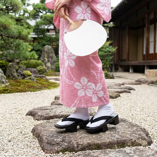 Geta Sandalen Damen getragen mit einem rosa Kimono in einem japanischen Garten