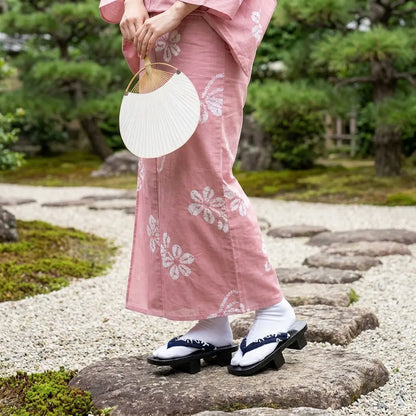 Geta Sandalen Herren getragen mit rosa Kimono in japanisch inspiriertem Garten