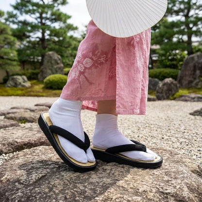 Geta Sandalen getragen mit rosa Kimono im japanischen Garten