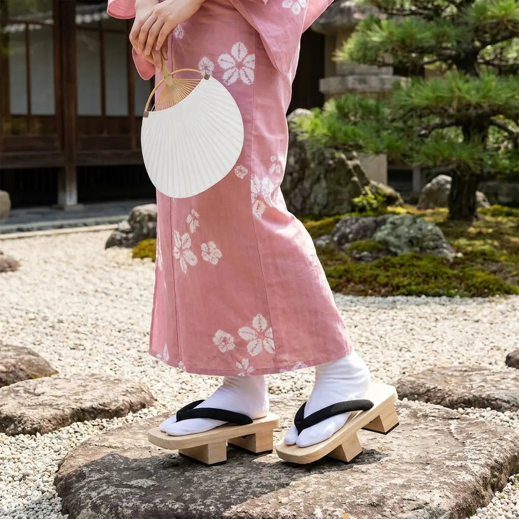 Geta Sandalen getragen mit rosa Kimono in einem japanischen Garten