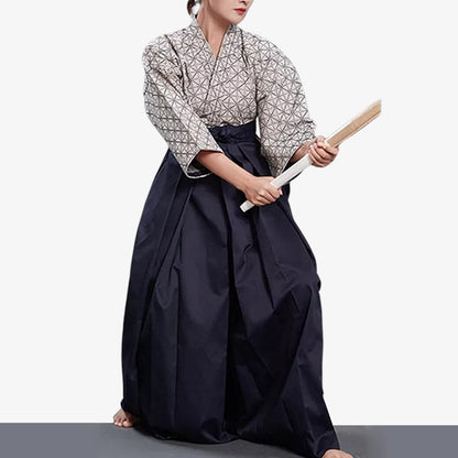 Person trainiert Aikido in blau-weißer Hakama Hose mit Holzschwert