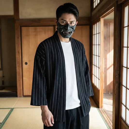 Mann trägt eine marineblau gestreifte Haori Jacke in einem japanischen Washitsu Zimmer
