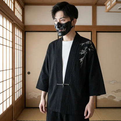 Mann trägt schwarze Haori Kimono Jacke in traditionellem japanischem Wohnraum, Frontalansicht