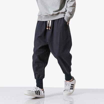 Mann trägt Harajuku Hose mit grauem Hoodie und weißen Sneakern für lässigen Look