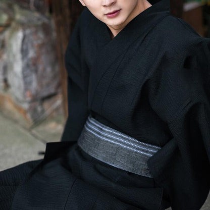 Mann trägt schwarzen Herren Kimono aus Baumwolle mit grauem Obi-Gürtel