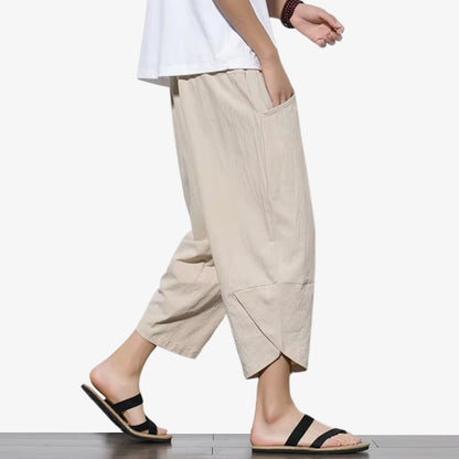 Mann trägt beige japanische Cropped Hose kombiniert mit schwarzen Sandalen
