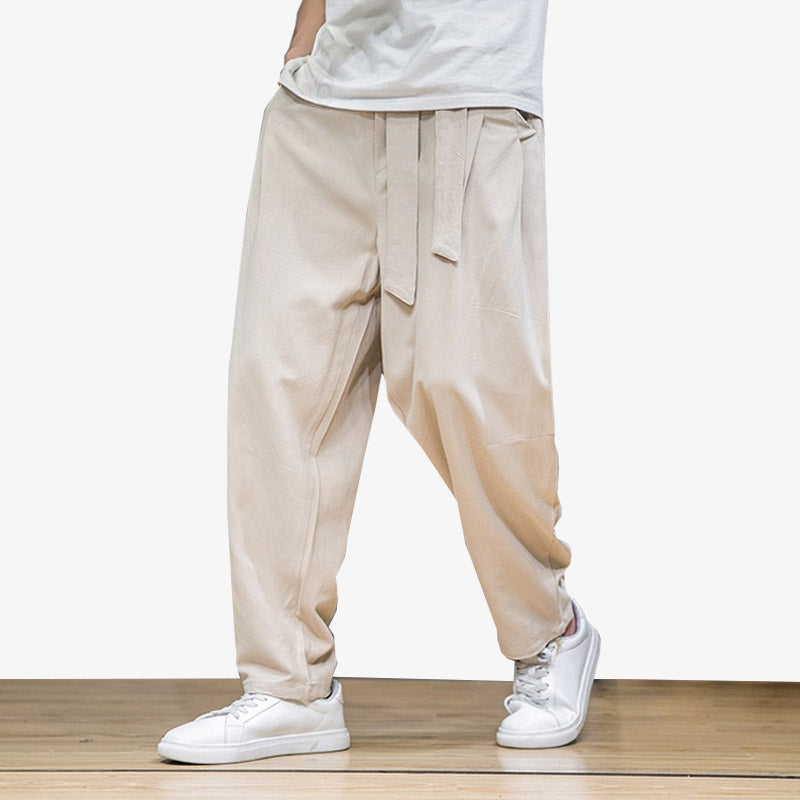 Mann trägt beige japanische Hose mit Gürtel und weißen Sneakers