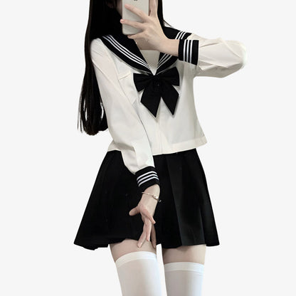 Frau im Cosplay mit schwarzem Rock, schwarzer Schleife und weißer Matrosenbluse
