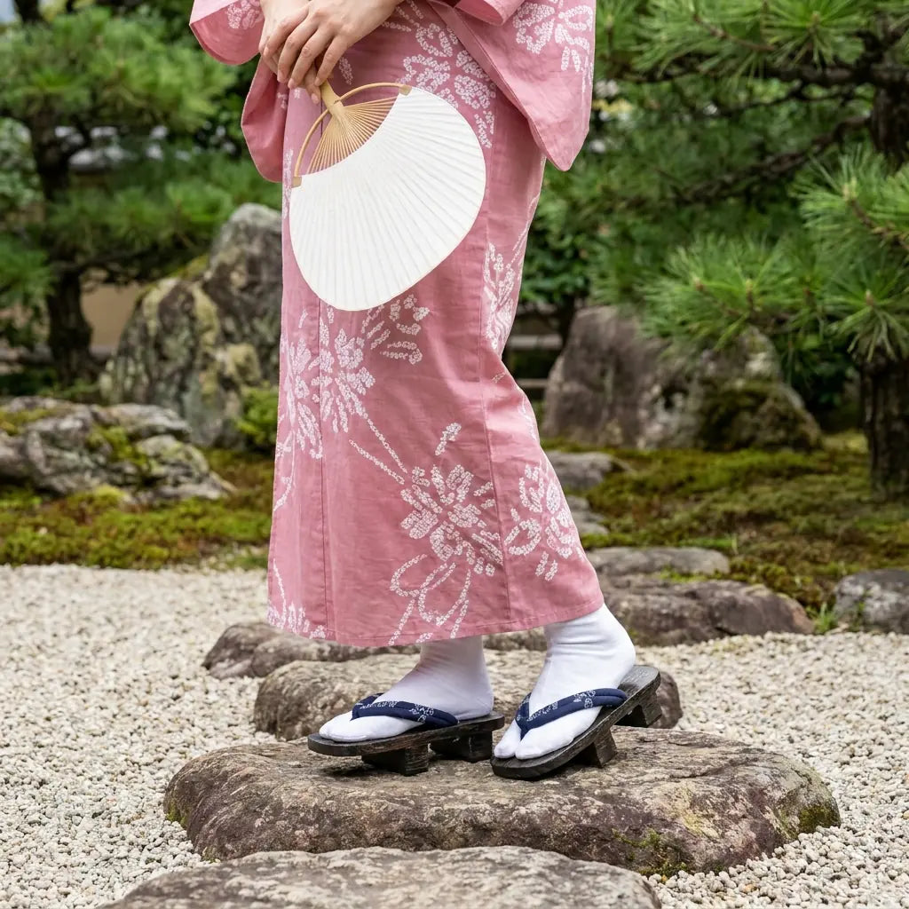 Japanische Schuhe Damen mit rosa Kimono in traditionellem japanischem Garten getragen