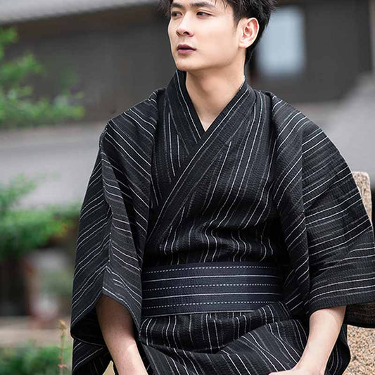 Mann trägt schwarz gestreiften Kimono mit japanischem Obi Gürtel