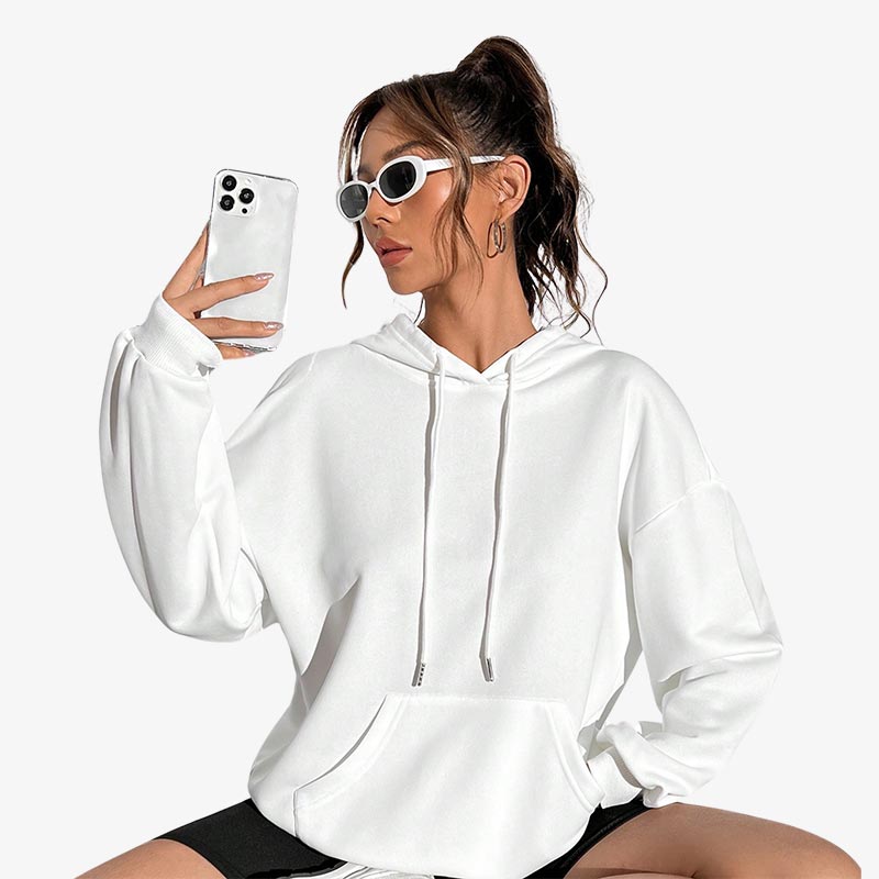 Frau im weißen japanischen Streetwear Hoodie mit Sonnenbrille und Smartphone