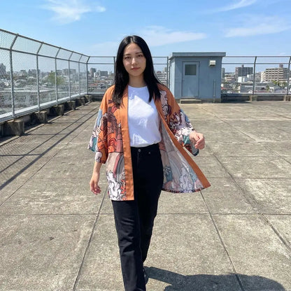 Kimono Jacke Damen in Orange und Blau mit Ukiyo-e Print auf einem Dach getragen