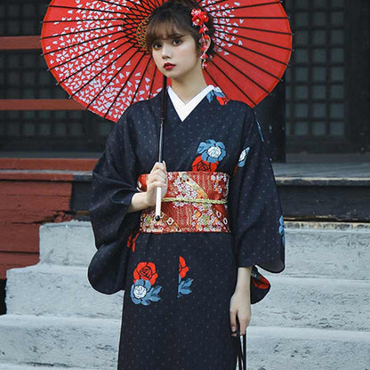 Frau im Kimono mit rotem Obi Gürtel und rotem Sonnenschirm