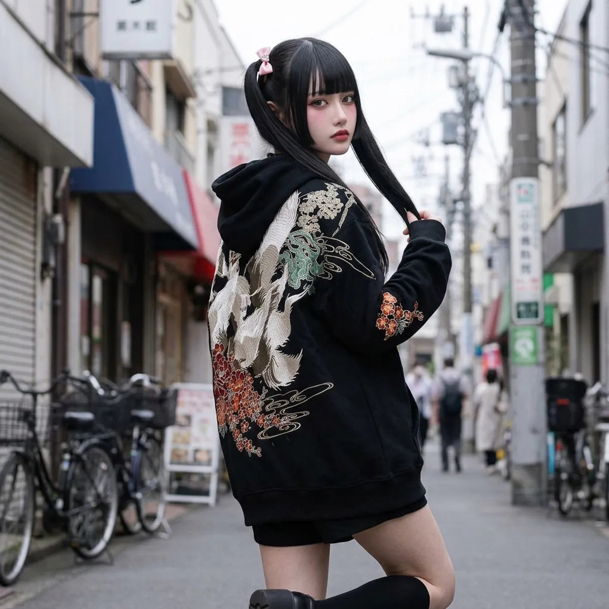 Frau trägt Kitsune Hoodie oversized im Streetwear Look und blickt über die Schulter auf den weißen Fuchs