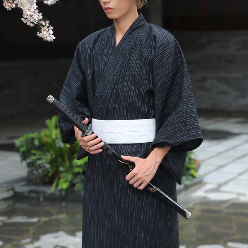 Mann im Kimono mit weißem Obi Gürtel hält ein schwarzes Katana