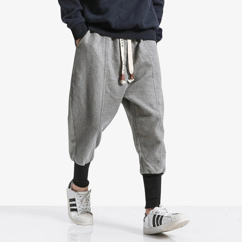 Mann trägt minimalistische graue Ninja Hose, die an den Knöcheln eng anliegt