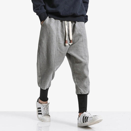 Mann trägt minimalistische graue Ninja Hose, die an den Knöcheln eng anliegt