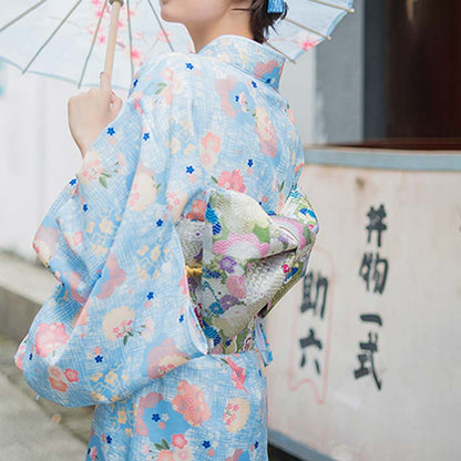 Frau in einer Straße trägt Obi Gürtel über einem geblümten Kimono-Kleid