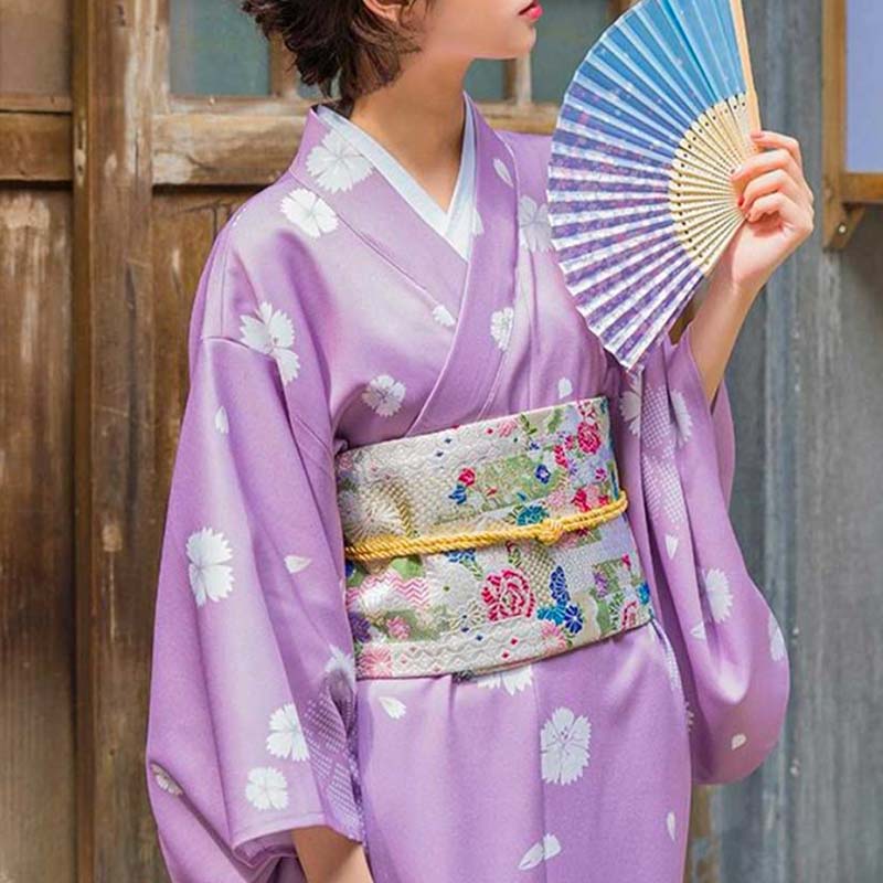 Stehende Frau bindet ihren Kimono mit einem traditionellen Obi Gürtel