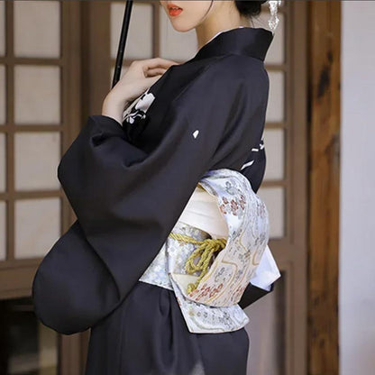 Frau trägt schwarzen Kimono mit passendem Obi Gürtel aus Baumwolle