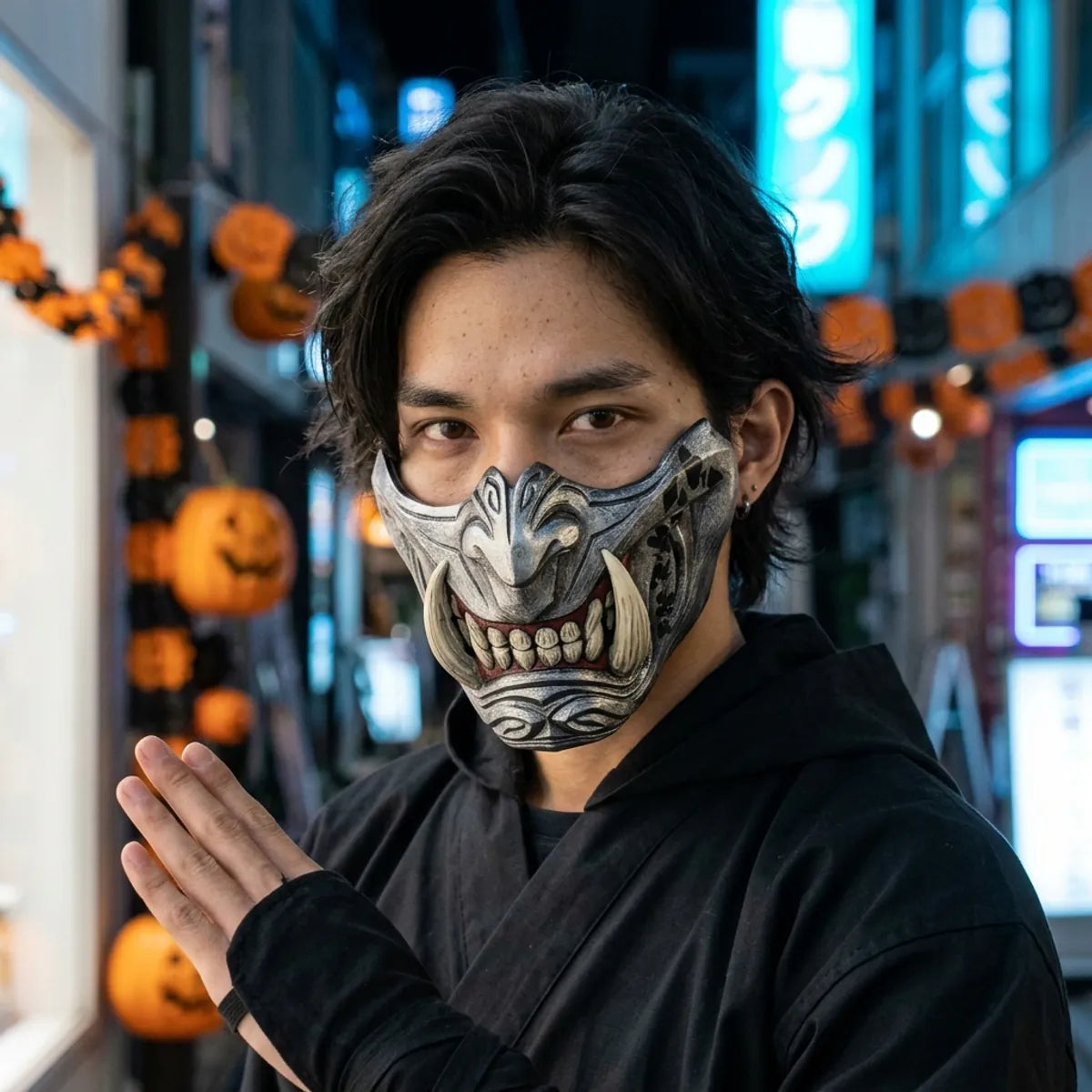 Silberne Oni Halbmaske mit Elfenbein-Zähnen bei Nacht mit blauem Tokio-Neonlicht