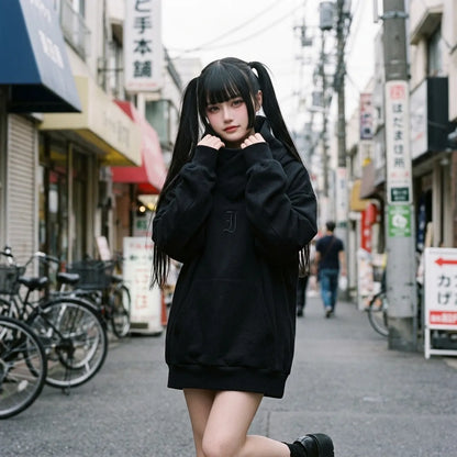 Schwarzer Oversized-Hoodie, getragen von einer Frau in Harajuku, der Trichterkragen eng um den Hals gewickelt