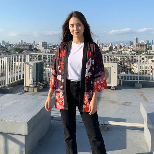 Rote Ombre Kimono Jacke für Damen offen getragen auf einem Dach über der Stadt