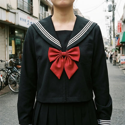 Nahaufnahme des schwarzen Sailor-Kragens mit weißen Streifen und roter Satinschleife