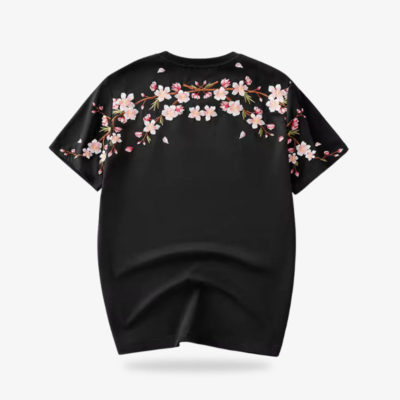 Schwarzes T-Shirt mit gestickter Kirschblüte vor weißem Hintergrund