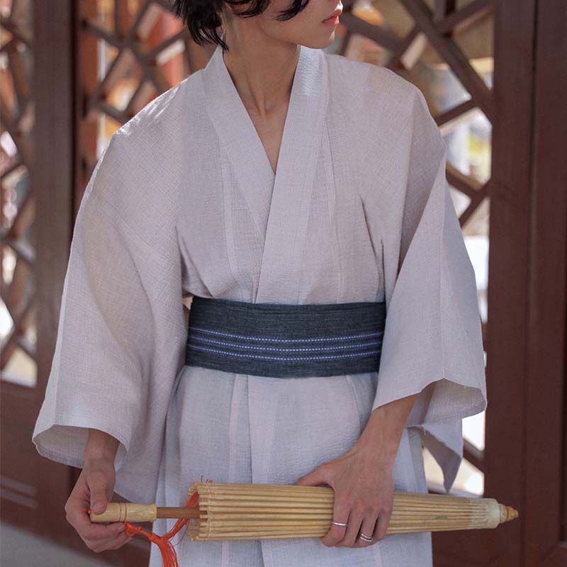 Mann im weißen Yukata trägt Samurai Obi Gürtel mit Bambusschirm