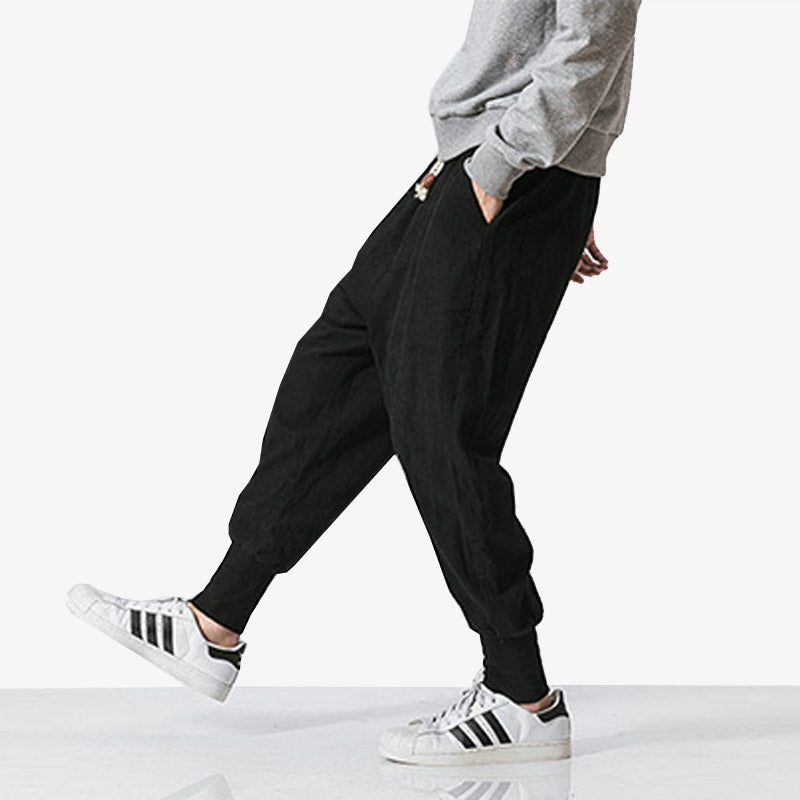 Mann trägt schwarze Cargo Hose mit Sneakers und grauem Sweatshirt