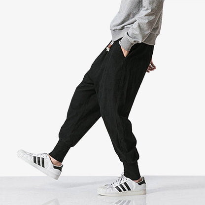 Mann trägt schwarze Cargo Hose mit Sneakers und grauem Sweatshirt