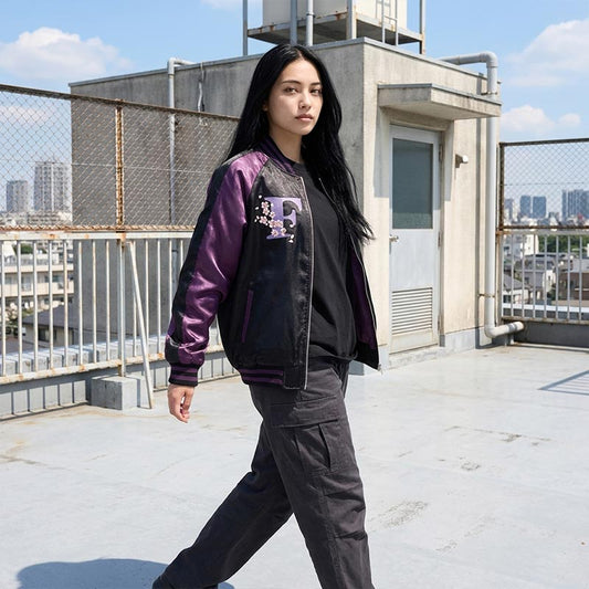Frau trägt lila Sukajan Jacke auf einem Schuldach mit Tokio im Hintergrund