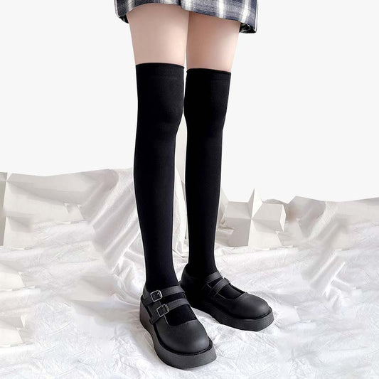 Frau trägt lange Tabi Socken zur Schuluniform mit kariertem Rock