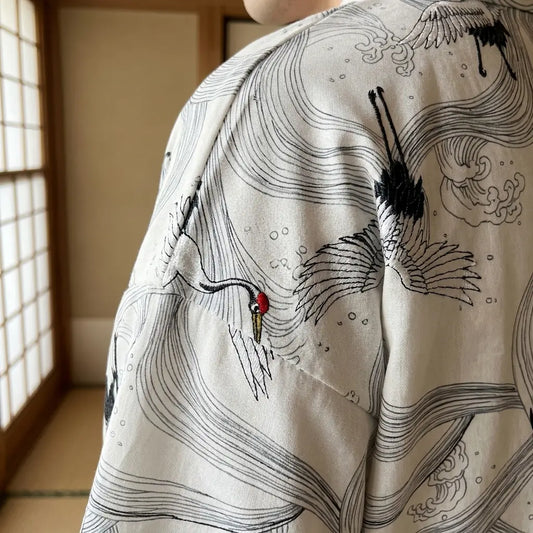 Detailaufnahme der Rückenstickerei am weißen Haori Kimono mit Kranichmotiv